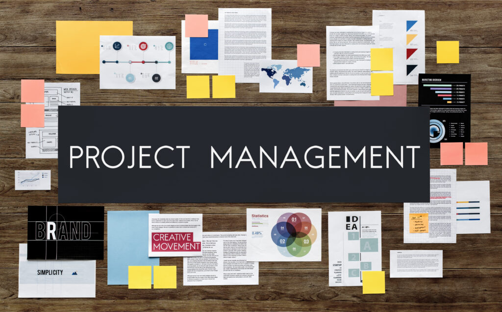 Project management planning board with strategy documents, sticky notes, infographics and statistics spread across a developer team workspace