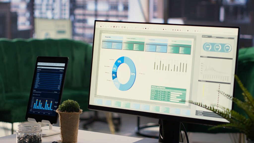 The Ultimate Project Management Software for Developers 2026 Guide Project management software dashboard displaying analytics charts and progress indicators on a monitor and tablet in a modern office