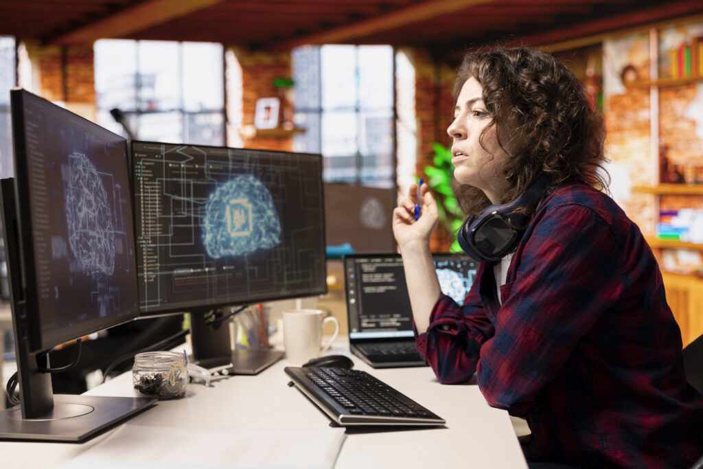 Female developer following claude code setup guide with AI brain visualization on dual monitor screen