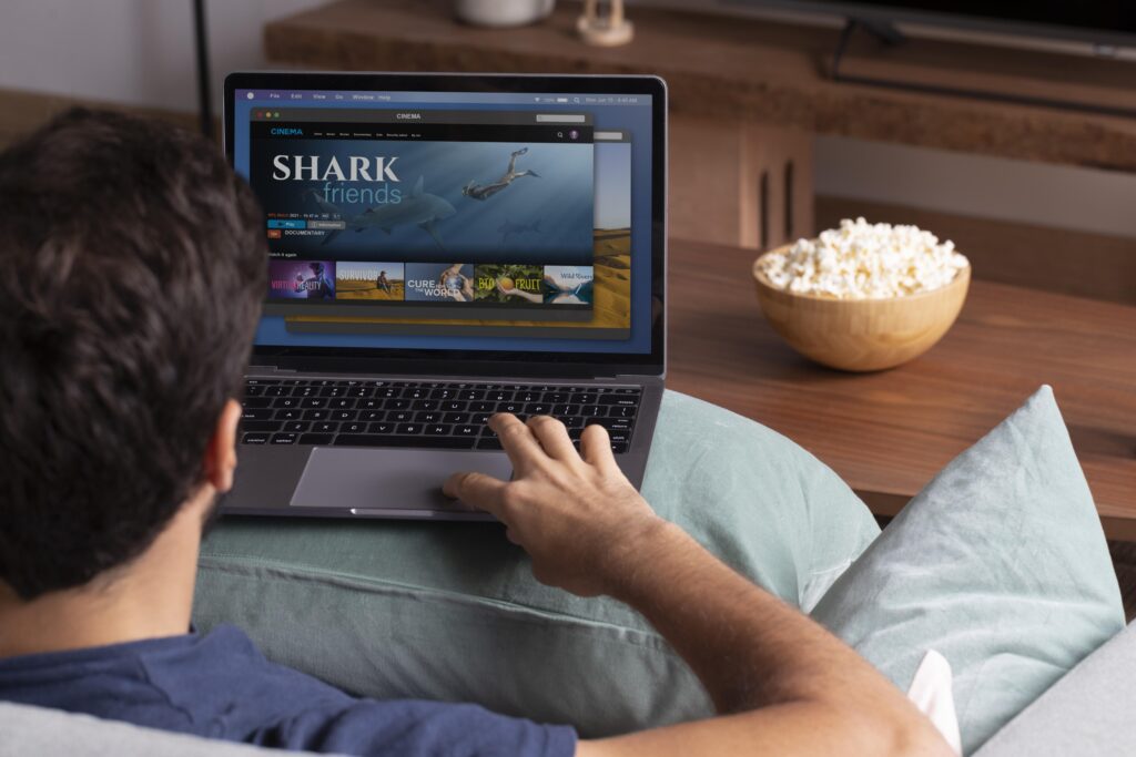 Man watching Hurawatch free streaming movies online on a laptop