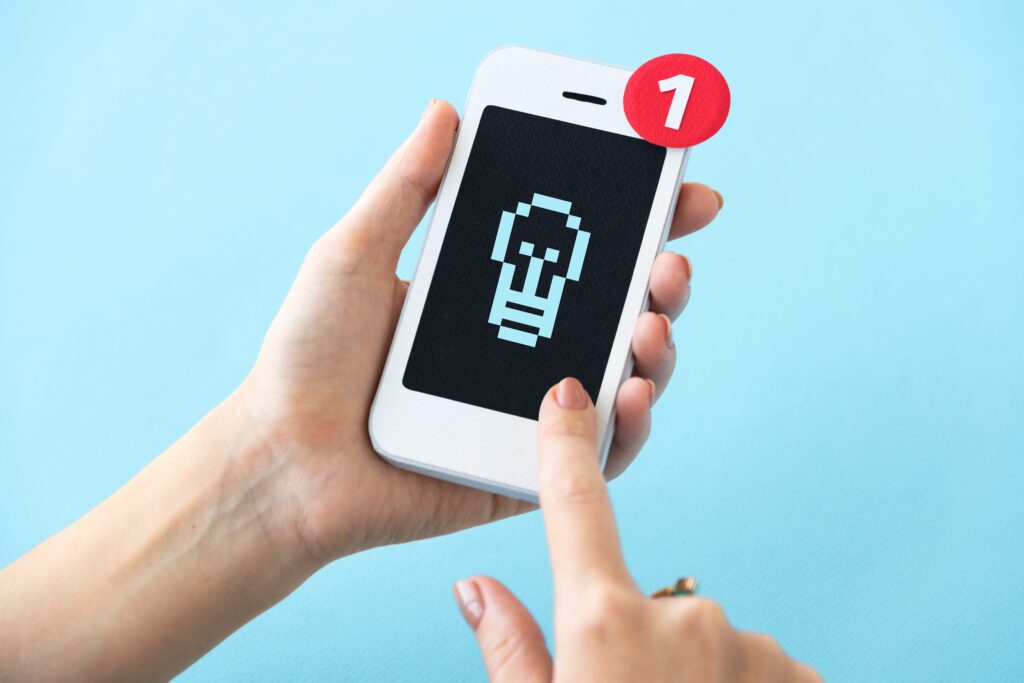 Hands holding mobile phone with red notification badge showing reddit comment removed alert checked via reveddit