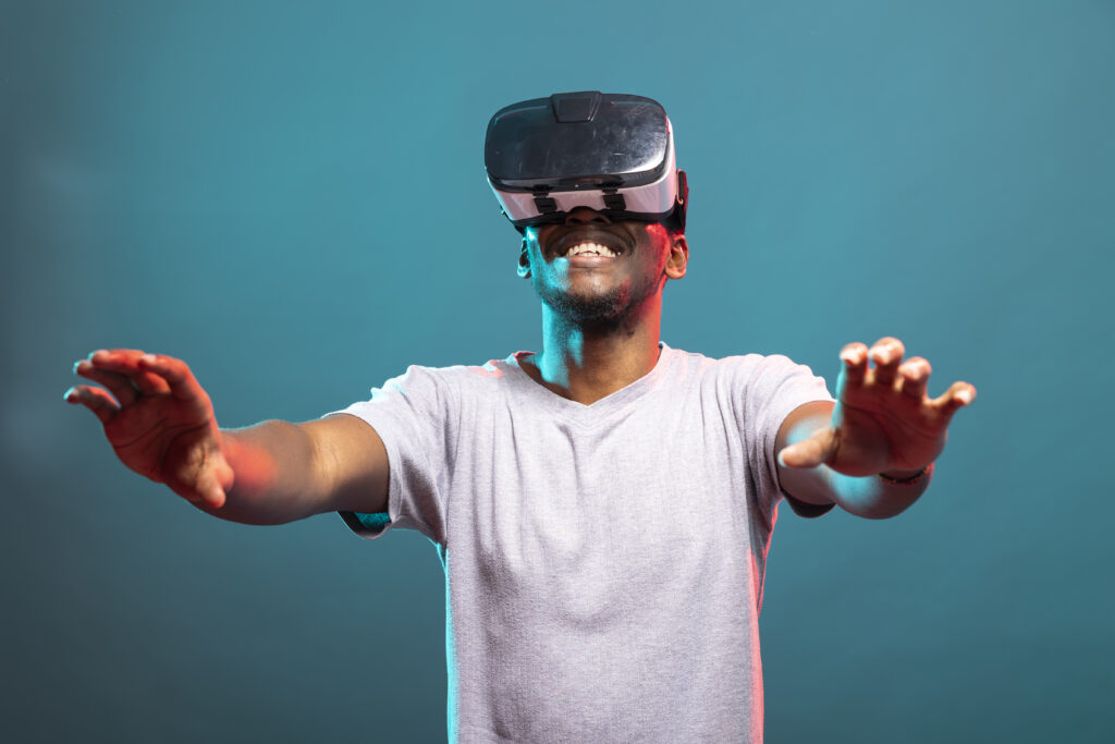 Man smiling while wearing a virtual reality headset and reaching out in an immersive VR experience